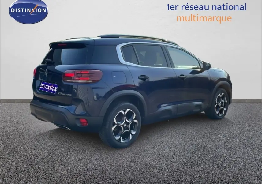 Vue 3/4 arrière droite d’un Citroën C5 Aircross bleu Eclipse Métal avec jantes bi-ton et toit noir.