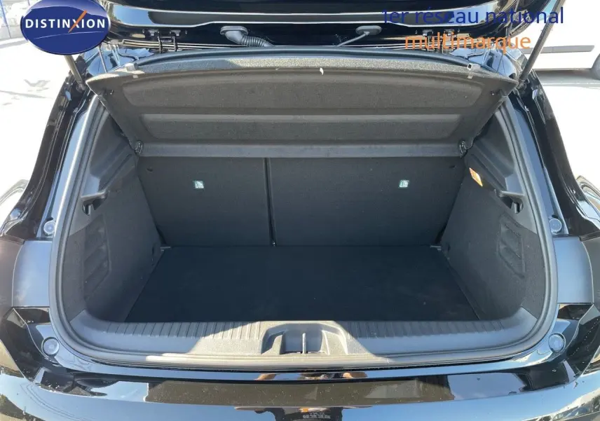 Coffre ouvert d'une Renault Clio TCE 90CH TECHNO noir métal, vue arrière montrant l'espace de chargement vide.