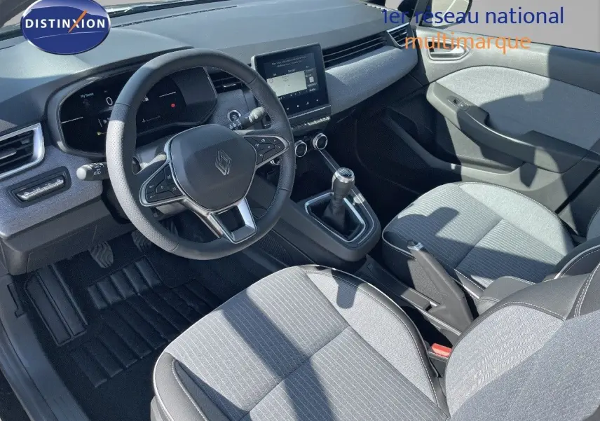 Intérieur de Renault Clio TCE 90CH TECHNO 2025, vue côté conducteur, sièges gris clair et volant multifonction noir.