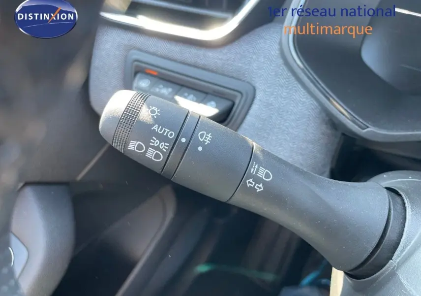 Gros plan sur la commande des phares et clignotants dans l'habitacle d'une Renault Clio noire 2025.