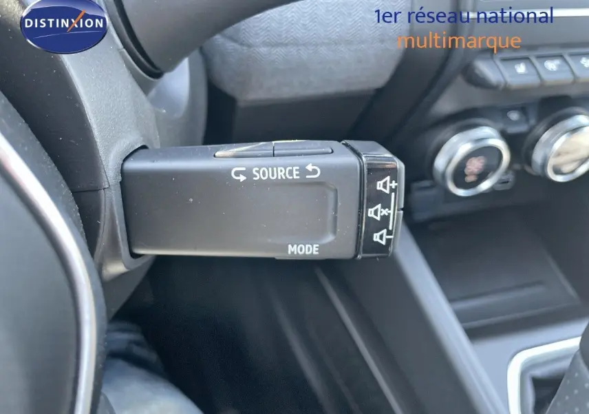 Gros plan sur la commande au volant de la Renault Clio TCE 90CH TECHNO 2025, intérieur noir avec boutons de source et mode.