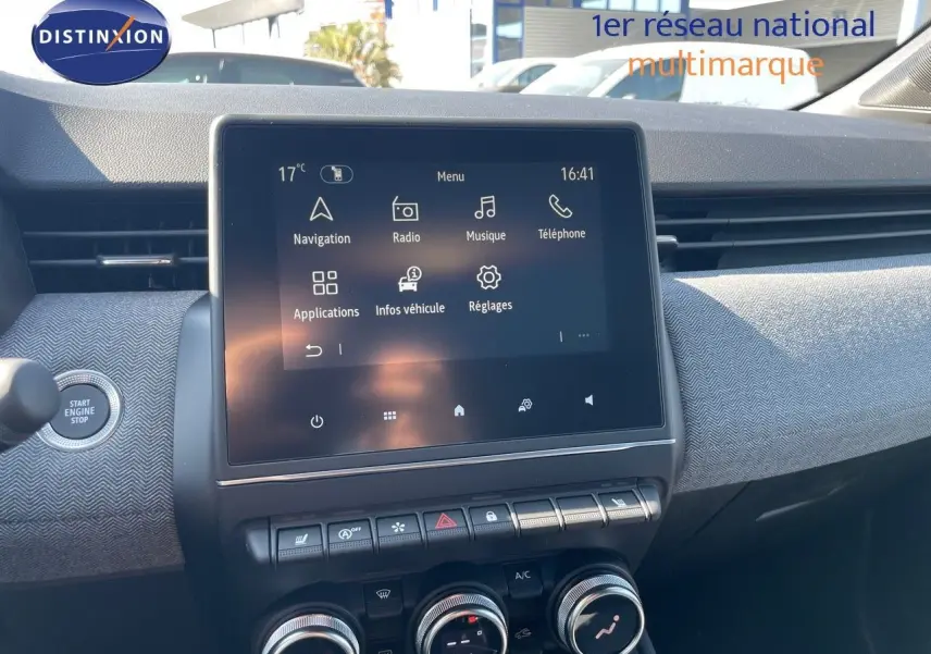 Vue rapprochée du tableau de bord de la Renault Clio 2025, écran tactile central avec commandes climatisation et bouton start noir.