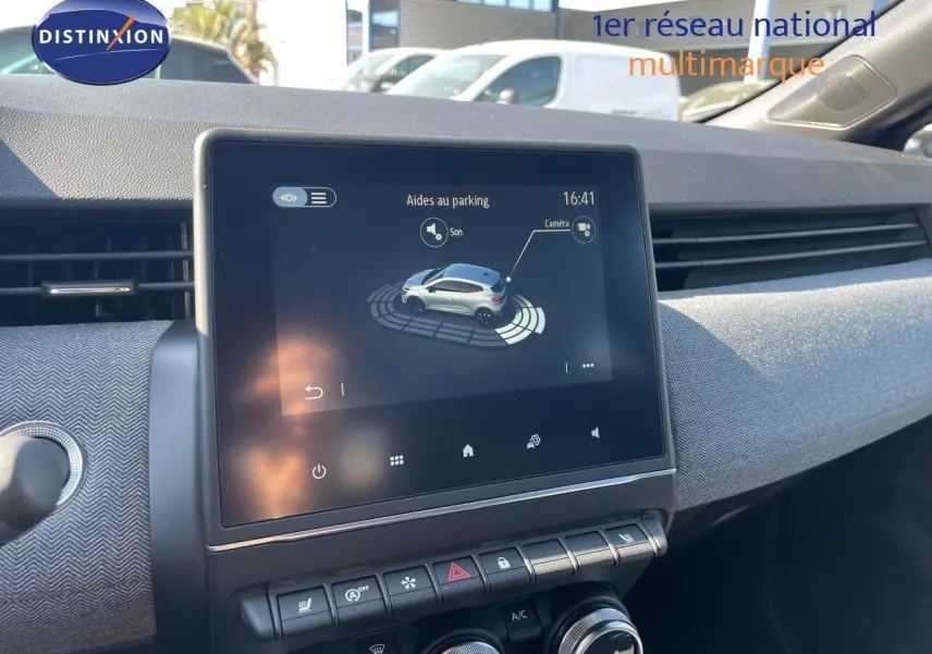 Écran tactile central affichant l'aide au parking dans l'habitacle d'une Renault Clio noir métal, vue de face.