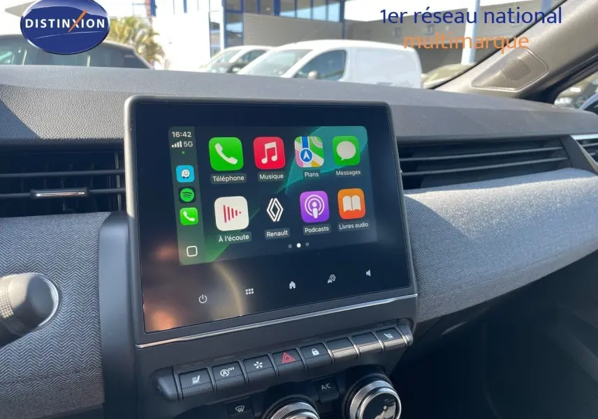 Tableau de bord de Renault Clio TCE 90CH TECHNO 2025, écran tactile central avec interface connectée et commandes climatisation visibles.