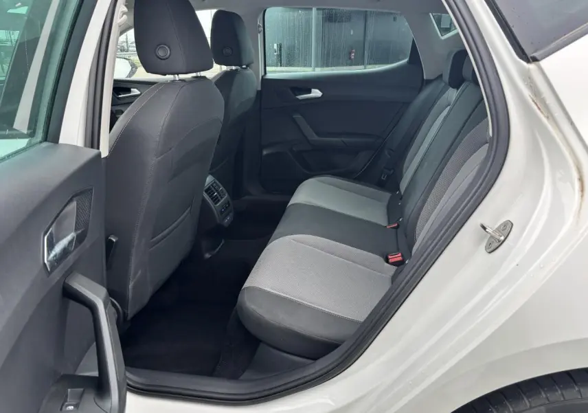 Vue côté gauche arrière du siège arrière gris et noir dans la SEAT LEON blanc 2024 avec portières ouvertes.