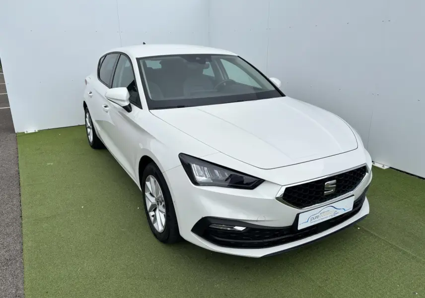 Vue 3/4 avant d'une SEAT Leon IV blanche avec jantes alliage 16 pouces et calandre hexagonale noire.