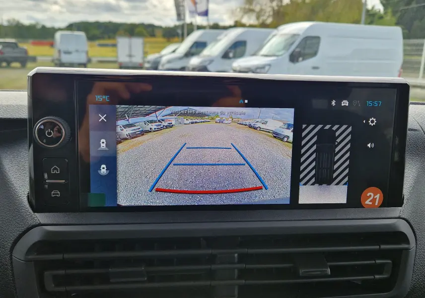 Écran de caméra de recul affichant une vue arrière avec lignes de guidage sur un Citroën Jumpy gris titane.