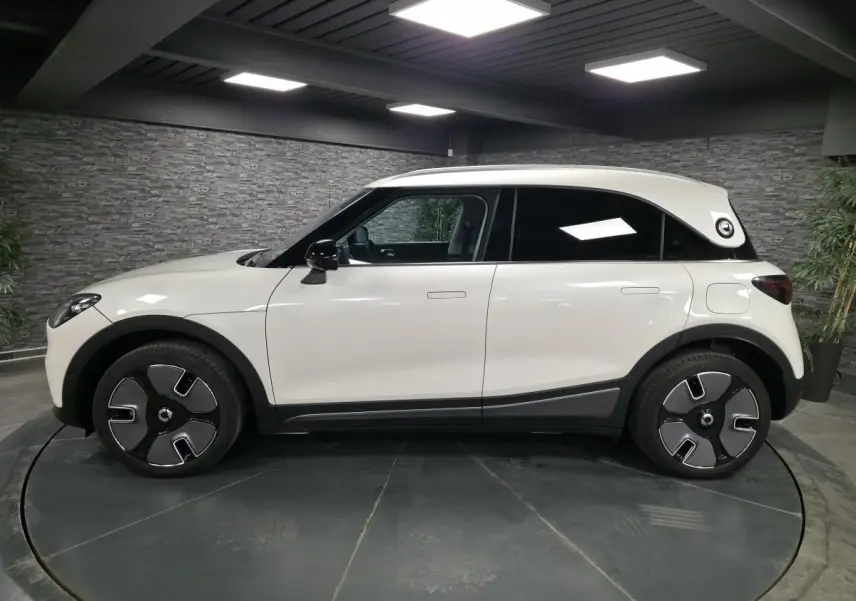 Vue latérale droite d'une Smart #1 blanche électrique avec toit blanc et jantes modernes en alliage.