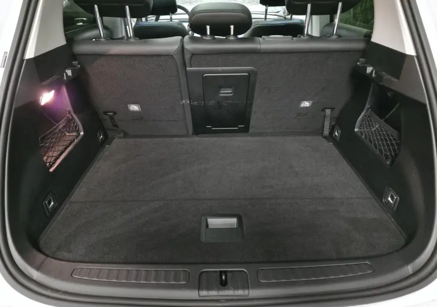 Coffre ouvert vu de l'arrière d'une Smart #1 blanche, avec banquette arrière noire et filet de rangement latéral.