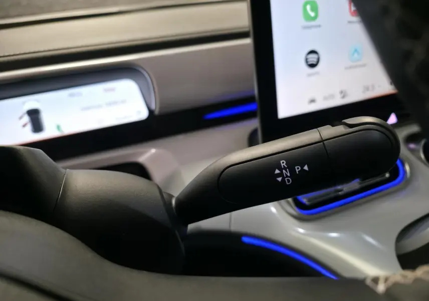 Le levier de boîte automatique noir du Smart #1 2024 visible en gros plan avec l'écran tactile et l'éclairage d'ambiance bleu.