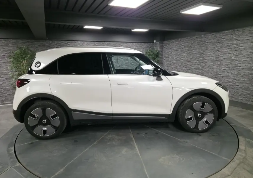 Vue latérale droite d'une Smart #1 blanche électrique 2024 avec jantes modernes et toit blanc contrasté.
