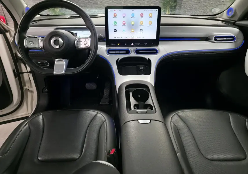 Intérieur avant du Smart #1 2024 blanc, tableau de bord moderne avec écran tactile central et éclairage d'ambiance bleu.