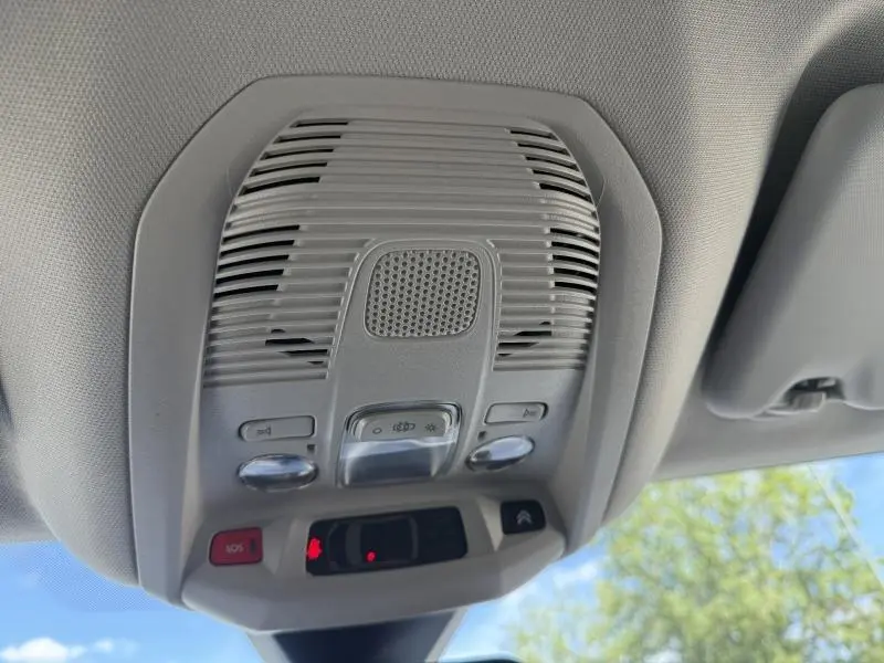 Vue en contre-plongée du plafonnier gris clair intérieur du Citroën C5 Aircross 2024 avec commandes et éclairage intégré.