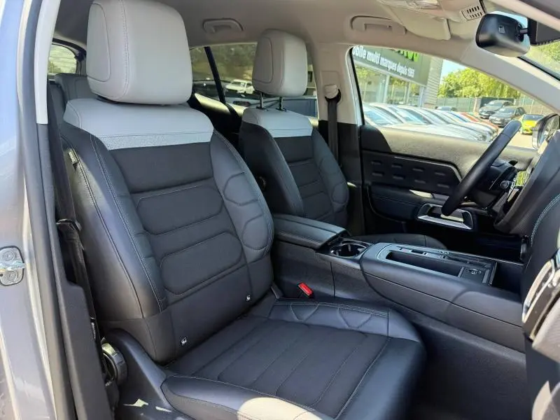 Vue intérieure côté conducteur du Citroën C5 Aircross gris acier, sièges avant en tissu et cuir noir avec surpiqûres grises.