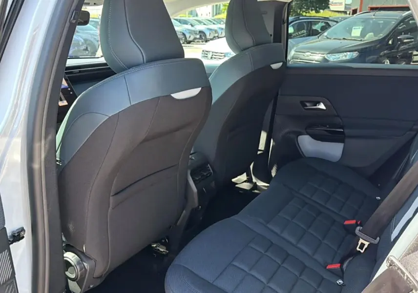 Vue arrière côté gauche de l’intérieur noir du Citroën C5 Aircross hybride 2026 avec banquette arrière et dossier des sièges avant.