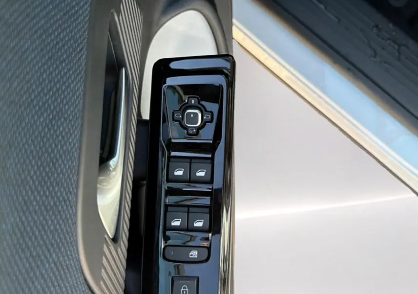 Gros plan sur la commande des vitres électriques côté conducteur d’un Citroën C5 Aircross blanc et noir.