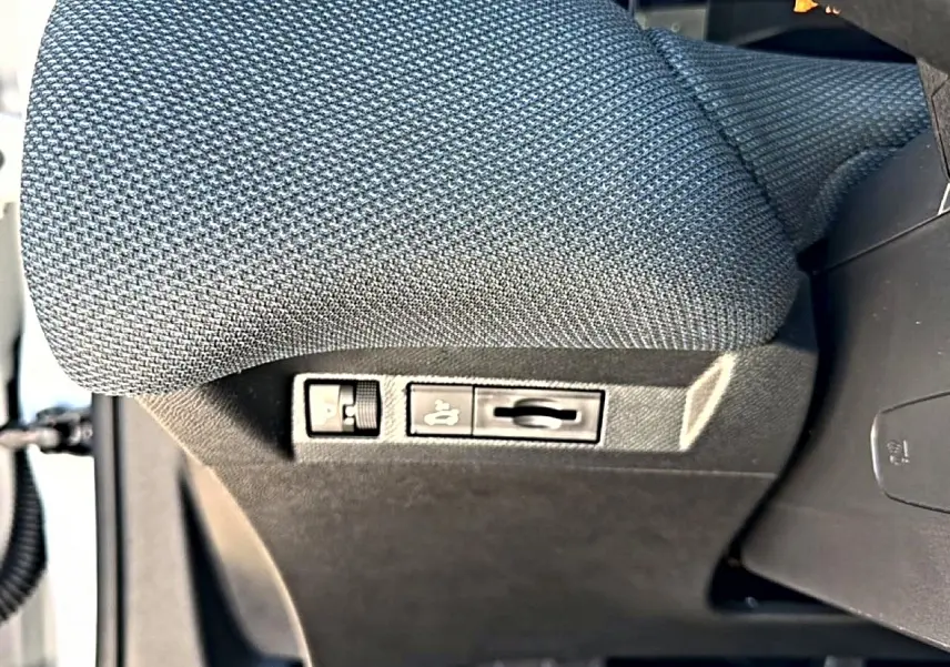 Gros plan sur les commandes de réglage du siège conducteur en tissu gris dans un Citroën C5 Aircross blanc 2026.