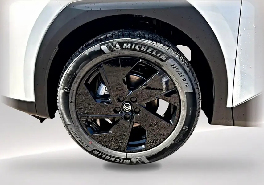 Gros plan sur la roue avant droite noire et jante alliage 19 pouces du Citroën C5 Aircross blanc et noir.