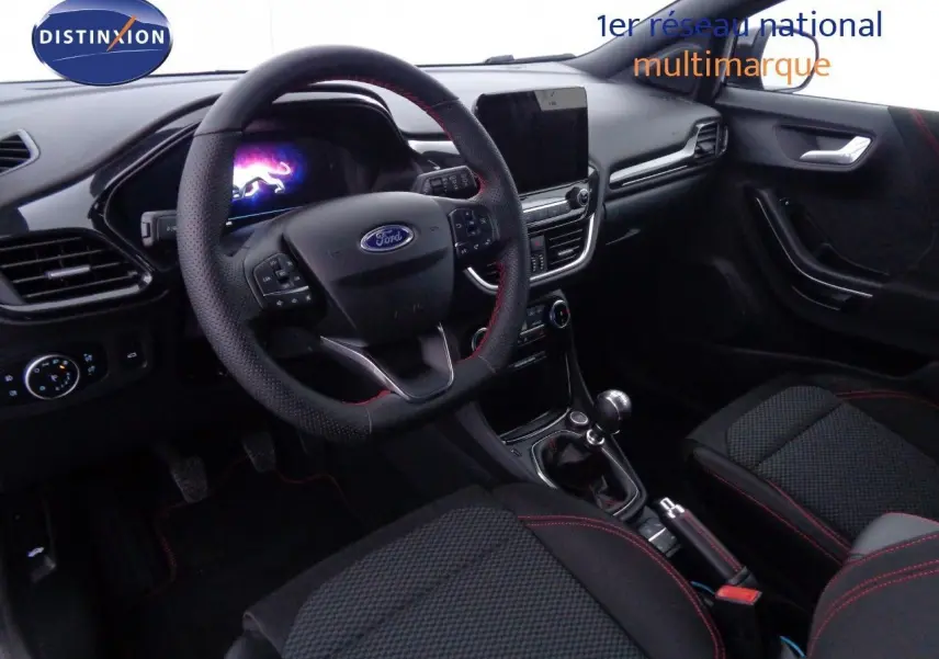 Intérieur avant du Ford Puma 1.0 EcoBoost MHEV 2022, volant cuir noir avec surpiqûres rouges et tableau de bord moderne.