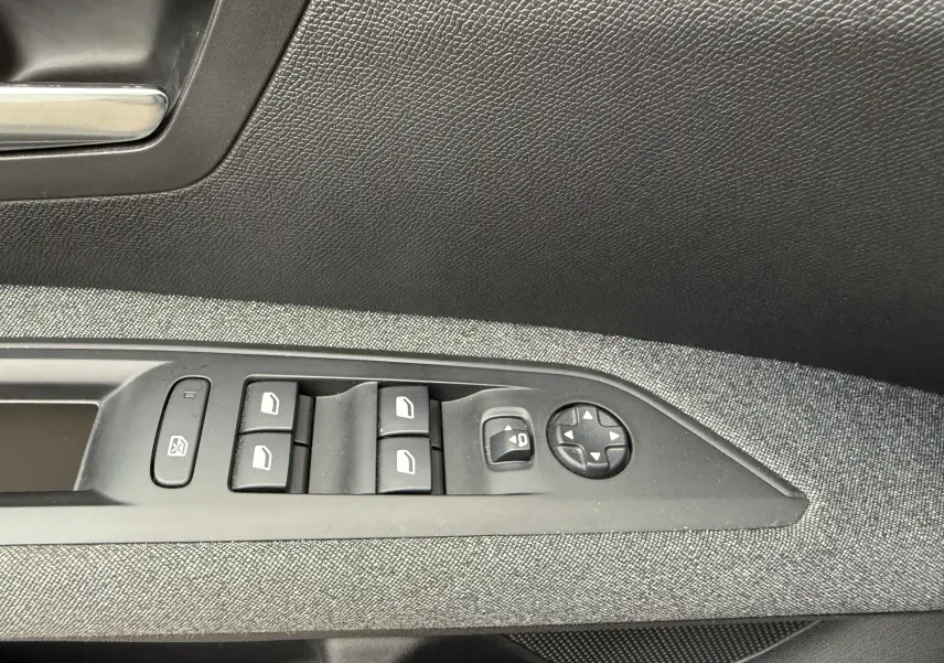 Détail des commandes de lève-vitres et réglage des rétroviseurs sur la porte côté gauche d’un Peugeot 5008 gris Artense 2020.