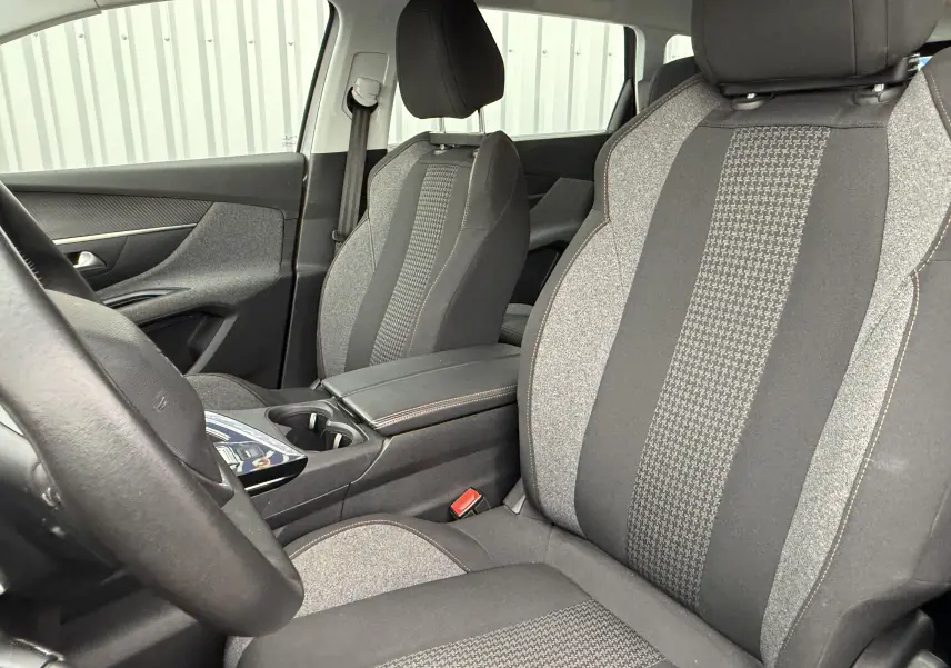 Intérieur du Peugeot 5008 2020, vue côté conducteur, sièges tissu gris à motifs et console centrale noire.