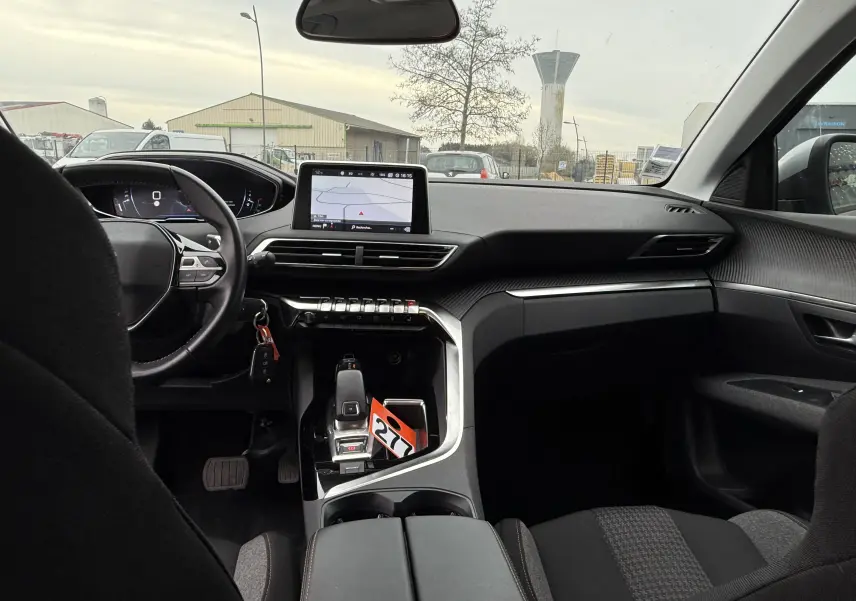 Vue intérieure avant du Peugeot 5008 gris Artense de 2020, montrant le tableau de bord avec écran tactile et volant multifonction.