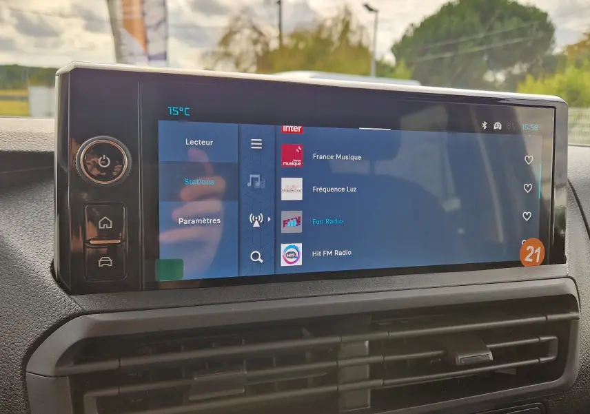 Écran tactile central du Citroën Jumpy XL gris titane, affichant les stations radio avec commandes latérales visibles.