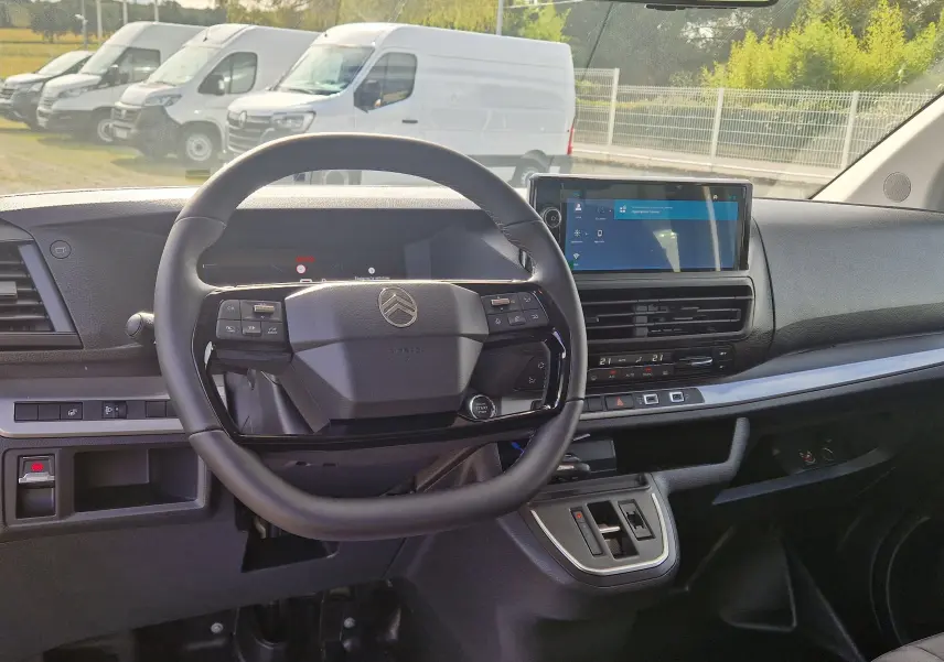 Vue intérieure du tableau de bord et volant noir du Citroën Jumpy Cabine Approfondie gris titane, avec écran tactile central.