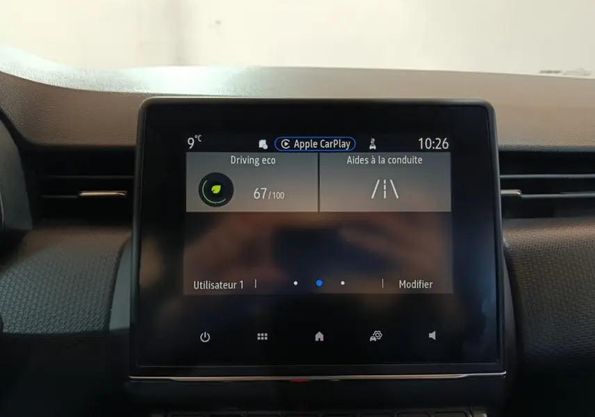 Écran tactile central de la Renault Clio gris clair, vue frontale du tableau de bord avec affichage Apple CarPlay.