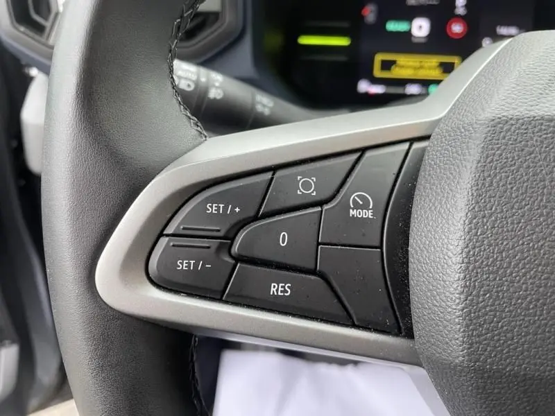 Gros plan sur les commandes au volant du Dacia Duster 1.6 Hybrid 140 cv 2025, boutons de régulateur de vitesse visibles.