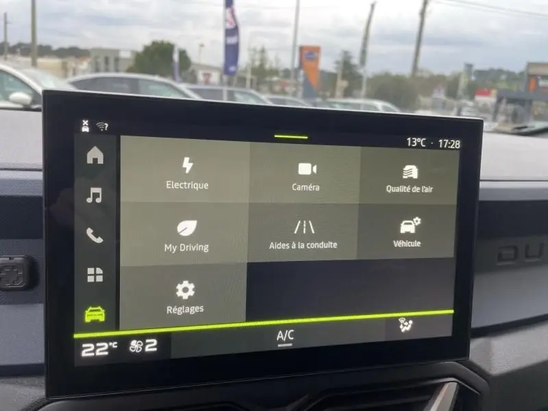 Écran tactile central du Dacia Duster 1.6 Hybrid 140 cv 2025, affichant les options de conduite et réglages, intérieur gris.