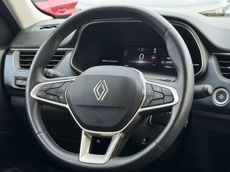 Vue rapprochée du volant multifonction noir du Renault Arkana 2025 avec tableau de bord numérique et bouton start/stop.
