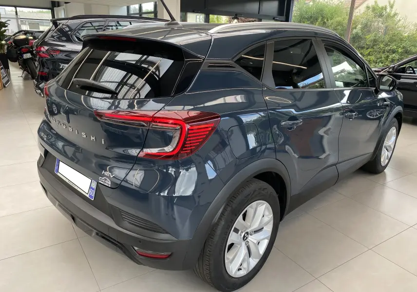 Vue 3/4 arrière droite du Mitsubishi ASX 2023 hybride en Steel Gray métallisé, avec feux arrière LED et jantes argentées.