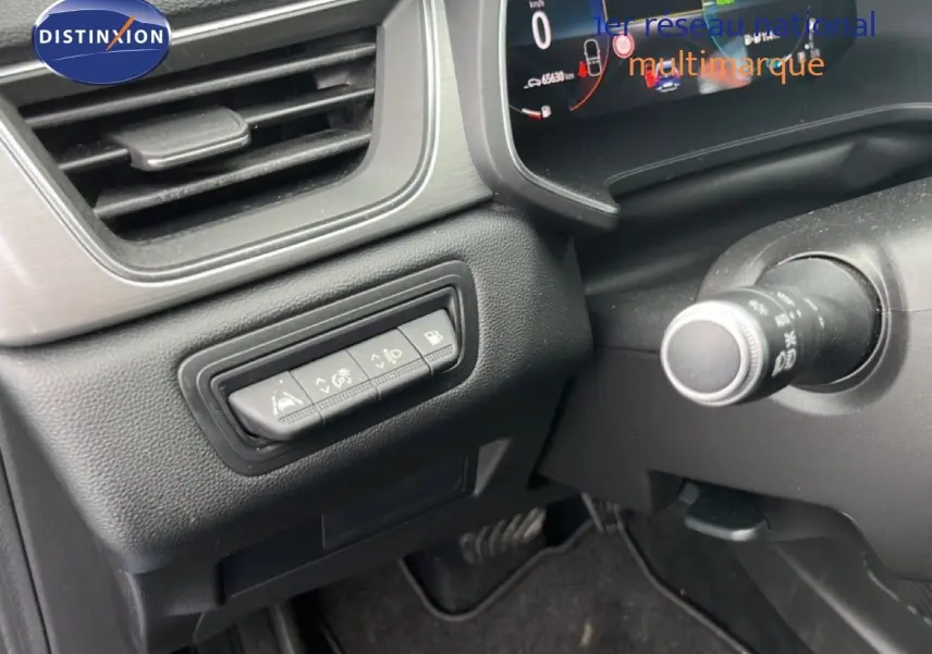 Vue intérieure côté gauche du tableau de bord du Renault Captur bleu iron metal avec toit noir, montrant les commandes d'assistance et l'écran digital.