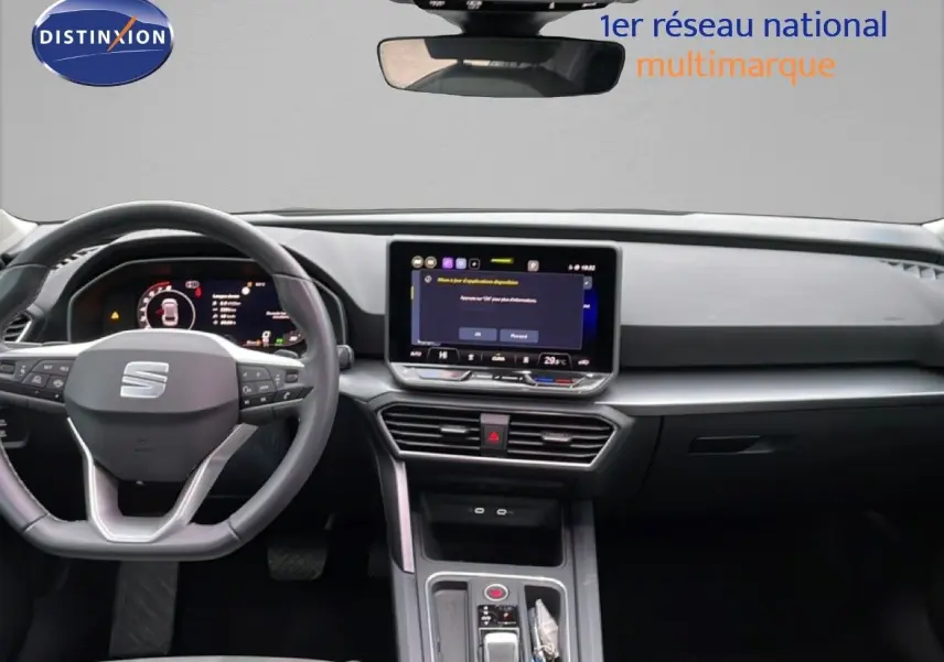 Vue intérieure frontale du tableau de bord et volant du SEAT Leon ST 2025 avec écran tactile central allumé.
