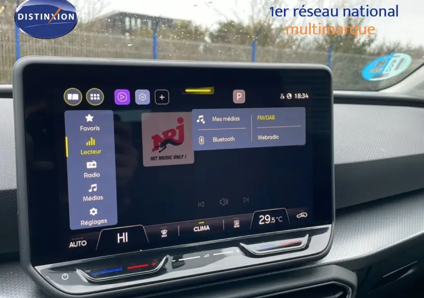 Vue rapprochée de l’écran tactile central du tableau de bord du SEAT LEON ST 2025, ambiance intérieure gris noir.
