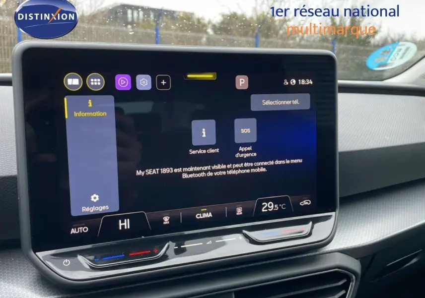 Écran tactile central affichant les réglages de climatisation dans l’habitacle gris-noir du SEAT LEON ST bleu Fjord.