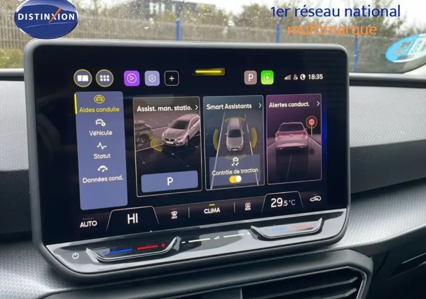 Vue intérieure centrée sur l'écran tactile du tableau de bord du SEAT LEON ST bleu Fjord, affichant les aides à la conduite.