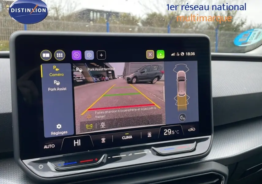 Écran central affichant la caméra de recul et l'assistance au stationnement dans un SEAT LEON ST bleu Fjord.