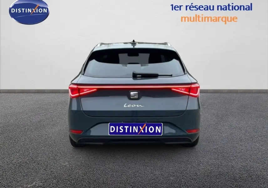 Vue arrière d'un SEAT Leon ST bleu Fjord 2025 avec feux LED reliés et logo distinctif au centre du hayon.