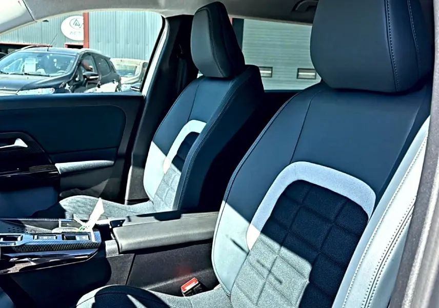 Vue intérieure rapprochée des sièges avant bicolores noirs et gris du Citroën C5 Aircross hybride 2026.
