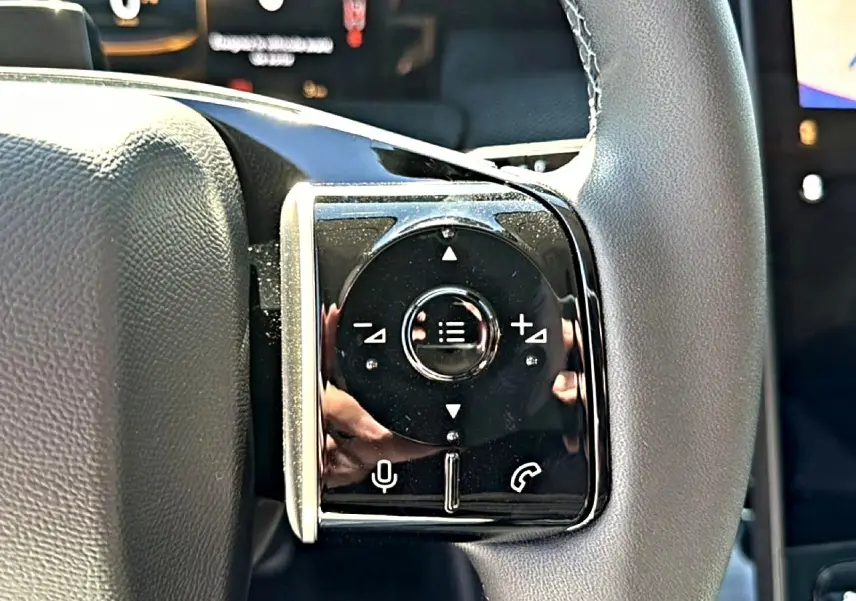 Gros plan sur les commandes multifonctions à droite du volant cuir gris du Citroën C5 Aircross hybride 2026.