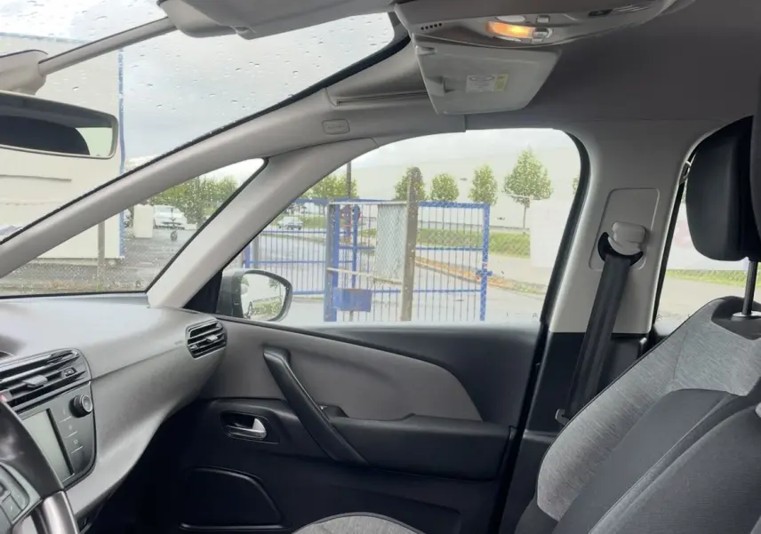 Vue intérieure côté passager avant d'une Citroën C4 Picasso 2017, sièges gris et noir avec tableau de bord visible.