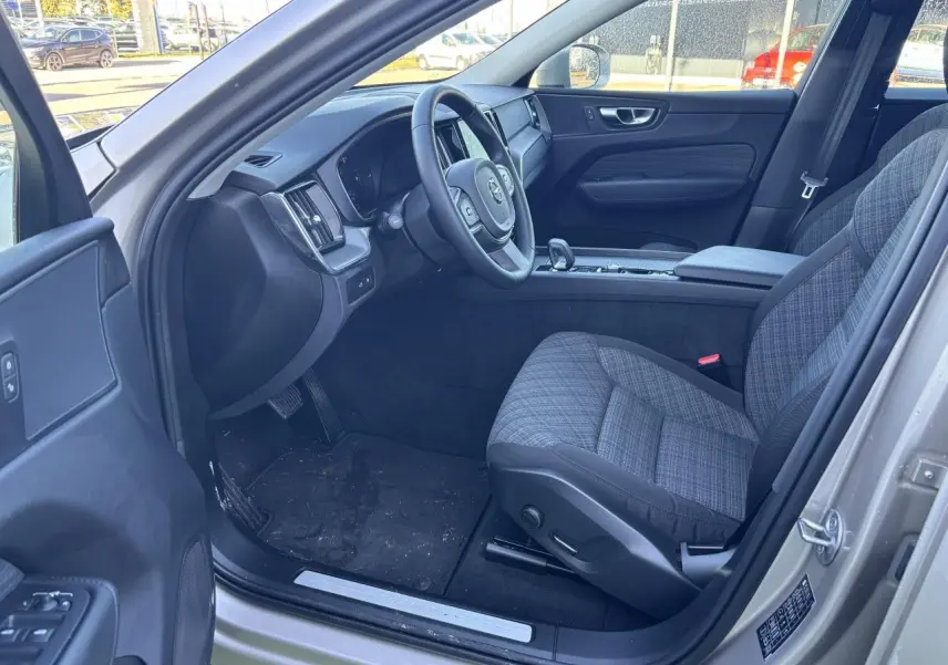 Intérieur côté conducteur du Volvo XC60 argent crépuscule, volant 3 branches et sièges tissu gris à motifs.