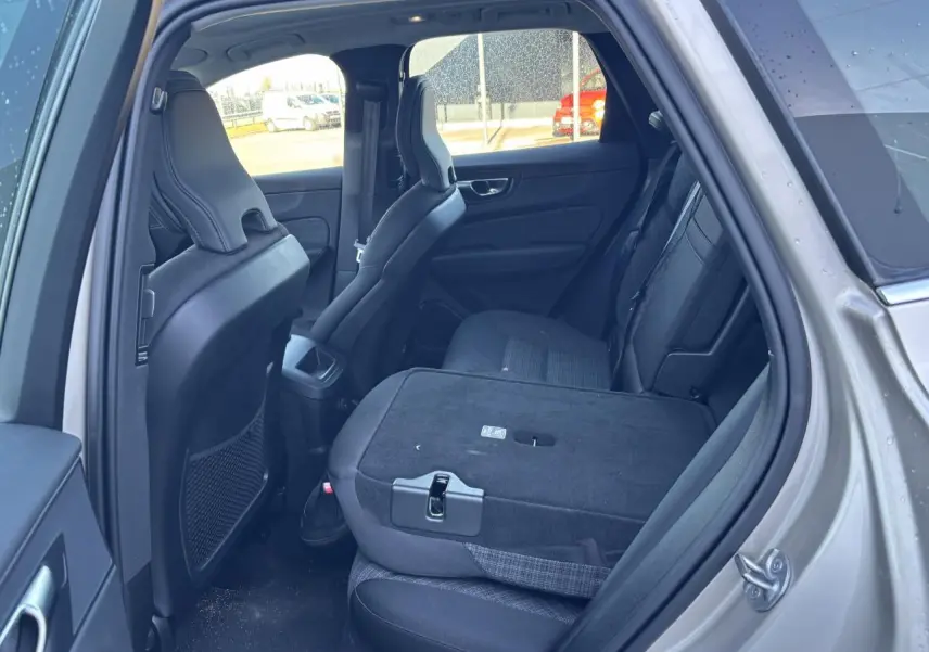 Vue intérieure côté gauche du Volvo XC60 argent crépuscule, siège arrière rabattable et dossier partiellement abaissé.