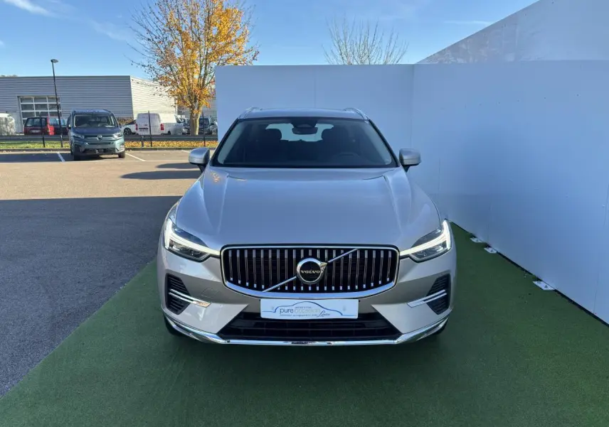 Vue frontale d'un Volvo XC60 2024 argent crépuscule métallisé avec calandre verticale et phares LED allumés.