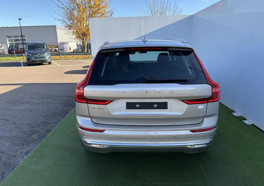 Vue arrière d'un Volvo XC60 argent crépuscule métal avec feux arrière LED en forme de L et hayon électrique.