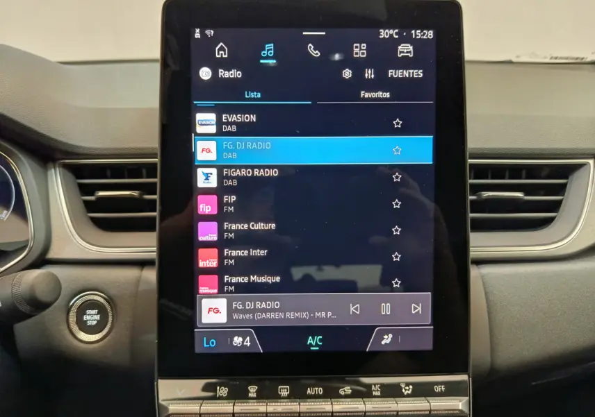 Écran tactile central du tableau de bord du Renault Captur gris foncé, affichant les stations radio et commandes climatisation.