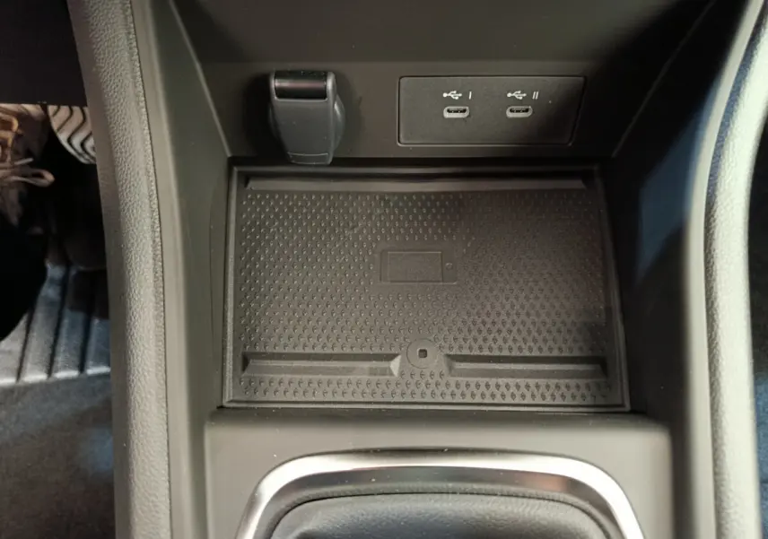 Gros plan sur la console centrale noire du Renault Captur 2025 avec ports USB-C et espace de rangement antidérapant.