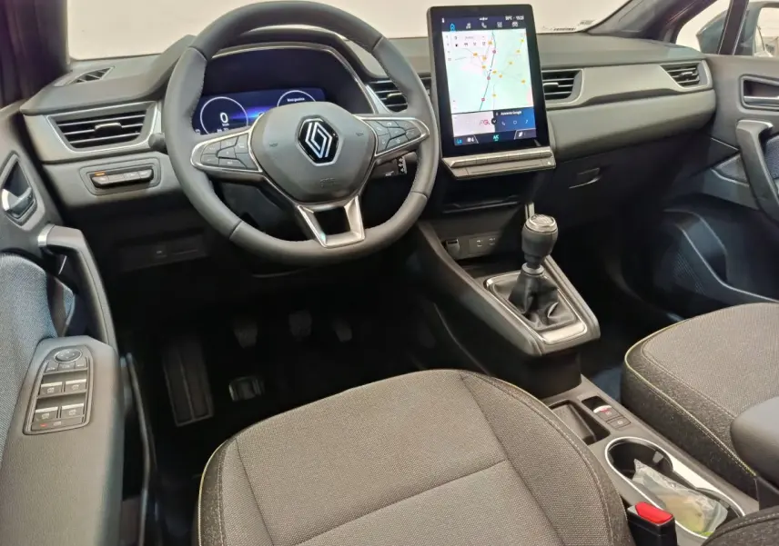 Intérieur du Renault Captur 2025 vu de face, volant multifonctions, écran tactile vertical et levier de vitesse manuel.